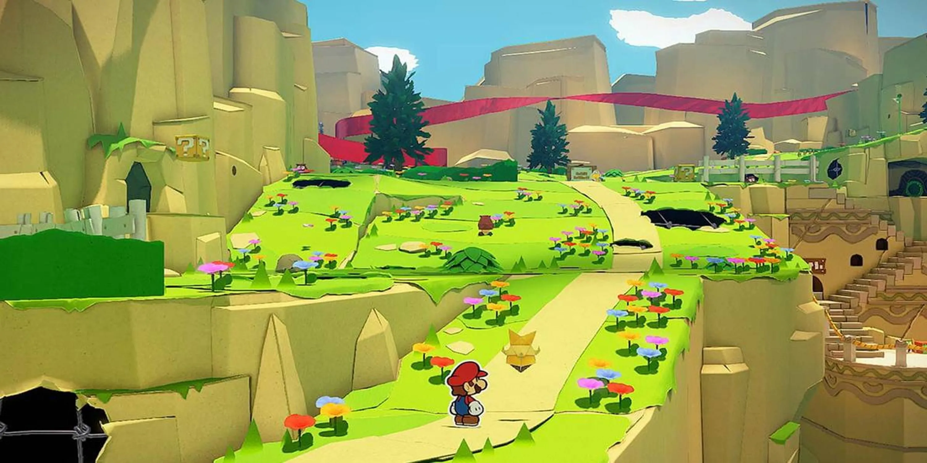 Mario đứng trên con đường giấy đầy màu sắc dẫn đến lâu đài trong Paper Mario The Origami King